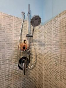 a shower in a bathroom with a brick wall at Home Sweet Home in Bareggio