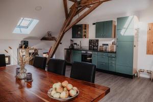 uma cozinha com uma mesa de madeira e armários verdes em Casa Cara: Retreat Apartment Sauna em Tacherting