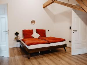 a bedroom with a bed with red pillows on it at Casa Cara: Retreat Apartment Sauna in Tacherting