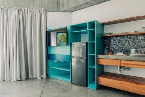 a kitchen with a refrigerator and a sink at Puro Surf Hotel & Performance Academy in El Zonte