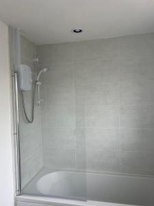 a bathroom with a shower with a bath tub at The Coral Guest House 1 Fratton Park Portsmouth in Portsmouth