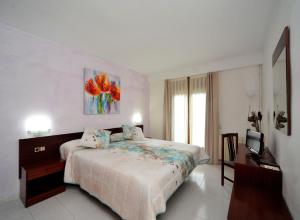 a bedroom with a large bed and a television at Hotel Vall d´Aneu in Esterri d'Àneu