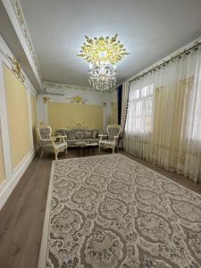 a living room with a couch and a chandelier at Apartment Vefa Center in Dushanbe