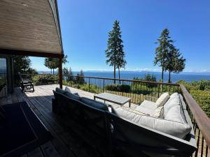 eine Terrasse mit Sofas und Meerblick in der Unterkunft Barooga: Stunning View Home in Halfmoon Bay, Canada in Halfmoon Bay