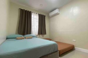 a bedroom with a blue bed and a window at Mid-rise Condo in Antipolo by Casa Akiolo in Antipolo