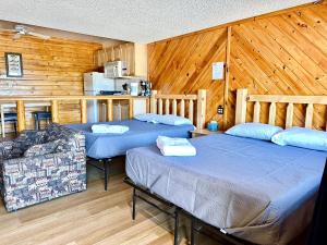 2 camas en una habitación con paredes de madera en Lakefront Escape, en Big Bear Lake