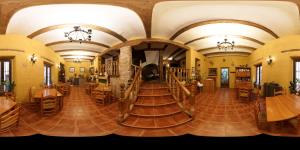 Habitación grande con suelo de madera, mesas y sillas. en Casa Rural Garrido en Ademuz