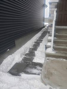 a snow covered sidewalk next to a house at Deluxe 2 bedroom suite with*Netflix/Cable/Prime in Edmonton