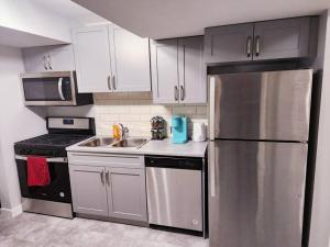 a kitchen with a stainless steel refrigerator and a sink at Deluxe 2 bedroom suite with*Netflix/Cable/Prime in Edmonton