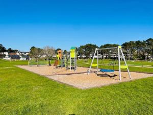 un parque con parque infantil con columpios en ARZON TERRASSE DE KERJOUANNO, en Arzon