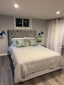 a bedroom with a large bed and two windows at Modern Beach House long stay discounts in Sarnia