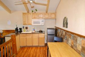 a kitchen with wooden cabinets and a table and a microwave at Lakefront Escape in Big Bear Lake +18 photos