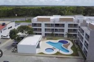 a large white building with a pool in front of it at Apartamento na Praia do Francês in Marechal Deodoro