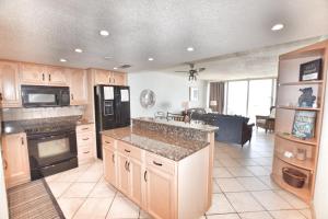 a kitchen with a black refrigerator and a stove top oven at 0611 Waters Edge Resort condo in Myrtle Beach