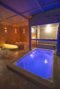 貢薩爾維斯的住宿－Pousada Colina das Andorinhas，带浴缸的客房内的大型游泳池