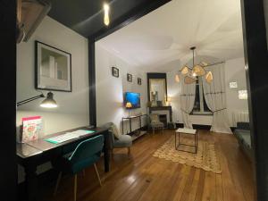 a room with a desk and a living room at Le Relais des Cordeliers in Nancy
