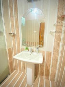 y baño con lavabo blanco y espejo. en Rudra_HomeStay, en Varanasi