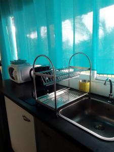 a kitchen sink with a dish drying rack on it at SUNSETVIEW, studio, private beach, amazing swim & sunset in Haapiti
