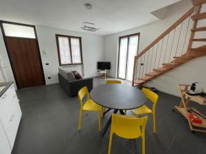 uma sala de estar com uma mesa e cadeiras amarelas em Appartamento Cavaria 416 em Cavaria