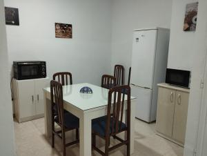 Casa Duque في برادو ديل ري: مطبخ مع طاولة وكراسي وثلاجة