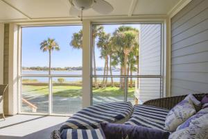 a living room with a couch in front of a window at Serenity in Folly Beach