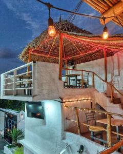 une maison avec un parasol, des chaises et une table dans l'établissement Posada Restaurant La Guaricha, à Catia La Mar