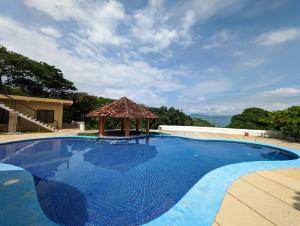 a large blue swimming pool with a gazebo at Cabinas Copal en Copal KiteBeach in Playa Copel