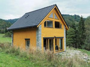 una pequeña casa con un techo negro en una colina en HillOut - Dom w Milówce - Workation - Praca zdalna, en Milówka