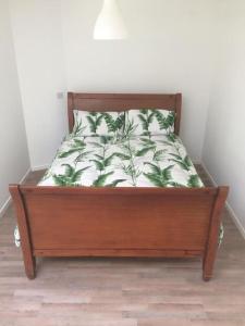 a bed with a wooden frame with a pillow on it at Eden Falls Studio in Crossabeg