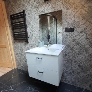a bathroom with a white sink and a mirror at Apartamenty u Pietrka in Kościelisko