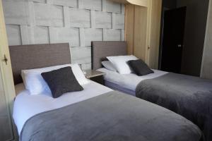 Huge 9 Bed Property Sleeps 17, Near NEC, City Centre, HS2 في برمنغهام: سريرين في غرفة فندق مع سريرين sidx sidx