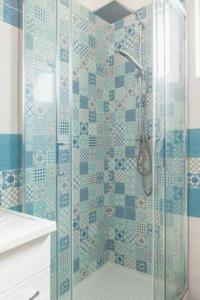 a bathroom with a shower with blue and white tiles at Casa Vacanze Nonna Rosaria al centro di Ascea Marina in Ascea +17 photos