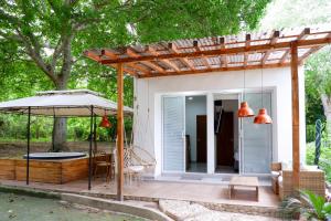 a patio with an umbrella and a house at Santuario Beach Hostel in Tierra Bomba