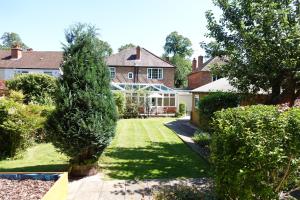a garden with trees and a house at Huge 9 Bed Property Sleeps 17, Near NEC, City Centre, HS2 in Birmingham
