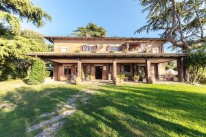 an old house with a large yard in front of it at Holiday House Borgo Badia in Castiglione del Lago