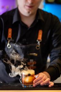 a man sitting at a table with a drink with smoke at Delta Hotels by Marriott Edmonton South Conference Centre in Edmonton