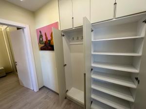 een kast met witte planken in een kamer bij T.A.O APARTMENT in Tirana