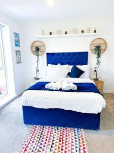 um quarto com uma cama azul com toalhas em Birmingham 3 Bedroom 2 Bath House Fully Furnished with Free Parking Private Garden Sleep up to 9 People Pets are allowed em Birmingham