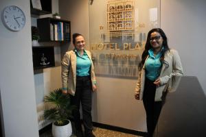 two people are standing in a room with a clock at Hotel Plaza El Santuario in Santuario