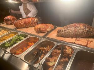 una persona parada en una cocina con un buffet de comida en The Bickford Arms Inn, en Holsworthy