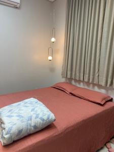 uma cama num quarto com uma janela e uma almofada em Sobrado no esperança da comunidade em Porto Velho