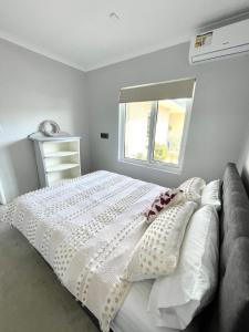 a bedroom with a white bed and a window at Ocean Reef Retreat in Perth