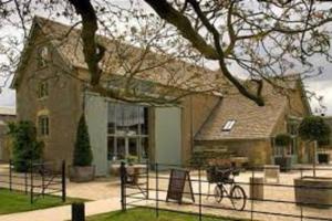 a house with a bike parked in front of it at Large Stylish Luxury Cotswold Cottage - ideal for families, w/ EV charging in Andoversford