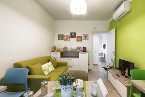 ein Wohnzimmer mit einem grünen Sofa und einer Küche in der Unterkunft B&B Civico 1 in Pavia