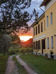 einen Sonnenuntergang hinter einem Haus und einer unbefestigten Straße in der Unterkunft Castel San Mauro in Gorizia