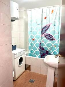 a bathroom with a washing machine and a shower curtain at Studio 6 in Podgorica