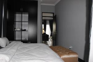 a bedroom with a large white bed and a black wall at MHP Apartments in Munyonyo