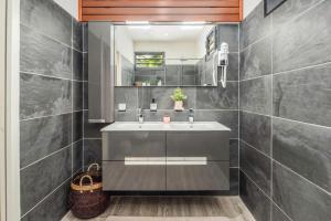 uma casa de banho com um lavatório e um espelho em HABITATION SUNSHINE - PISCINES PRIVÉES + SAUNA COMMUN em Saint-François
