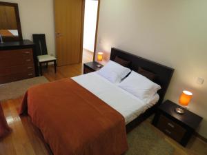 a bedroom with a large bed with white sheets and orange blanket at Casas Solar da Torre in Navais