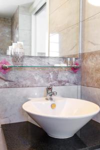 ein Badezimmer mit einem weißen Waschbecken und einem Spiegel in der Unterkunft Dunas of Love in Caleta de Fuste